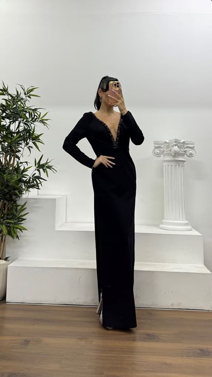 Schwarzes, tief eingefasstes, mit Steinen verziertes Abendkleid in besonderem Design